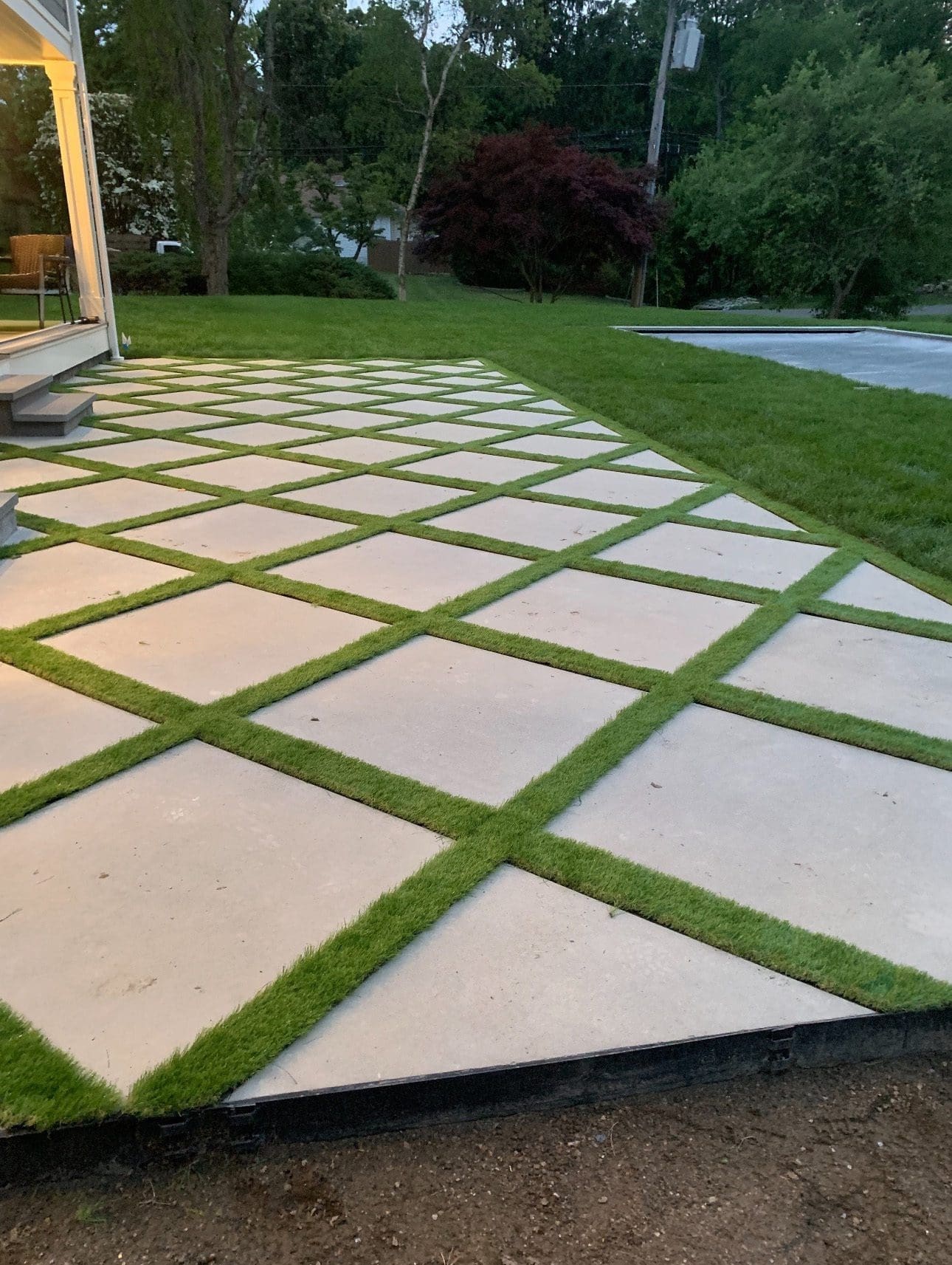 Modern patio with grass between paving stones.