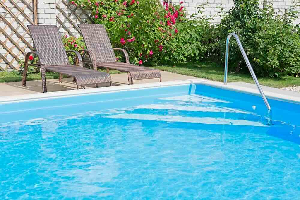 Backyard pool with lounge chairs and flowers